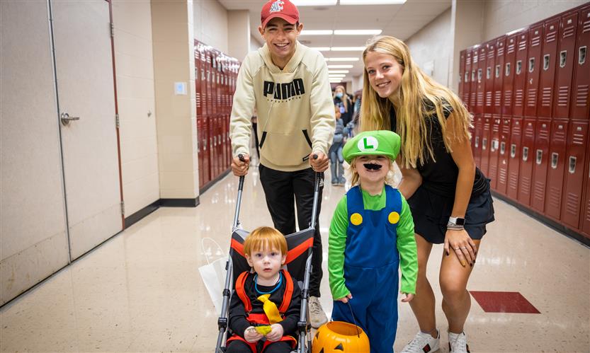Children in costume trick or treat around school